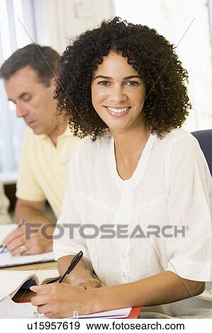 Stock Photo - Adult students studying at table (selective focus). Fotosearch