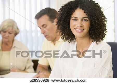 Stock Photo - Adult students studying at table (selective focus). Fotosearch