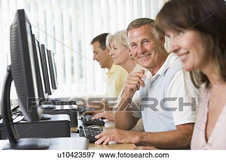 Four people sitting at computer terminals (selective focus/high key) View Large Photo Image Stock Photo - Four people sitting at computer terminals (selective focus/high key). Fotosearch