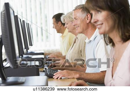 Four people sitting at computer terminals (selective focus/high key) View Large Photo Image Stock Photo - Four people sitting at computer terminals (selective focus/high key). Fotosearch