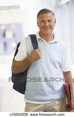 Man standing in corridor with backpack (high key) View Large Photo Image Stock Photograph - Man standing in corridor with backpack (high key). Fotosearch