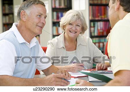 Three people in library writing in notebooks (selective focus) View Large Photo Image Stock Image - Three people in library writing in notebooks (selective focus). Fotosearch