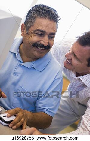 Two men at computer smiling and looking at each other (high key) View Large Photo Image Stock Photography - Two men at computer smiling and looking at each other (high key). Fotosearch