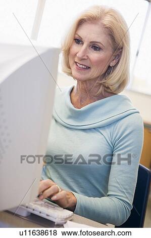 Woman sitting at computer typing (high key) View Large Photo Image Stock Photo - Woman sitting at computer typing (high key). Fotosearch
