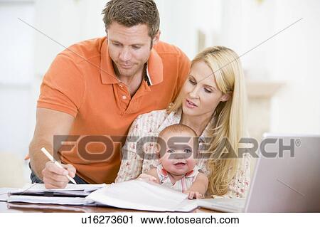 Couple and baby in dining room with laptop View Large Photo Image Stock Image - Couple and baby in dining room with laptop. Fotosearch