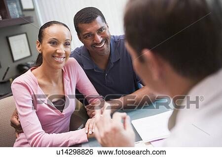 Stock Photograph - Couple in consultation at IVF clinic (selective focus). Fotosearch