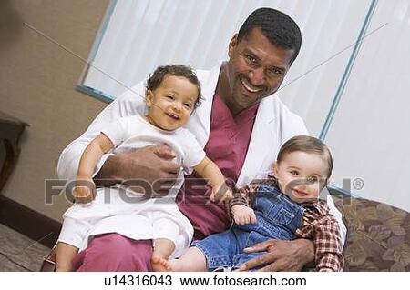 Stock Image - Doctor sitting with two IVF children smiling. Fotosearch