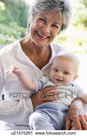 Stock Image - Grandmother outdoors on patio with baby smiling. Fotosearch