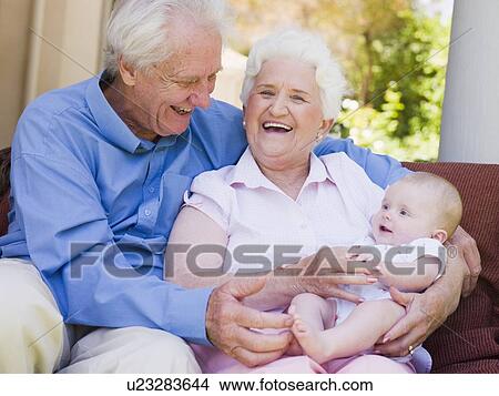 Grandparents outdoors on patio with baby smiling View Large Photo Image Picture - Grandparents outdoors on patio with baby smiling. Fotosearch