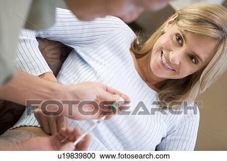 Stock Image - Man helping woman inject drugs to prepare for IVF treatment (selective focus). Fotosearch