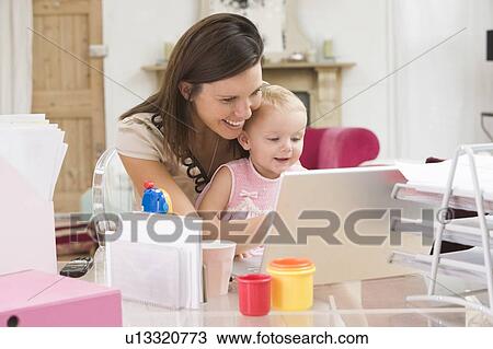 Mother and baby in home office with laptop View Large Photo Image Stock Image - Mother and baby in home office with laptop. Fotosearch