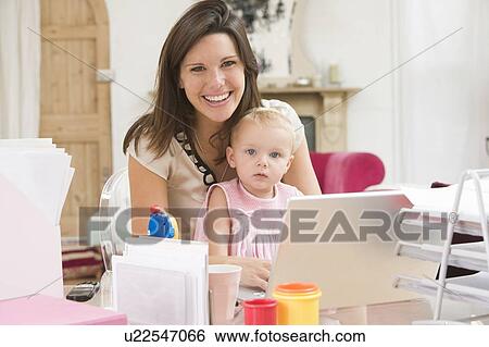 Mother and baby in home office with laptop View Large Photo Image Stock Photograph - Mother and baby in home office with laptop. Fotosearch