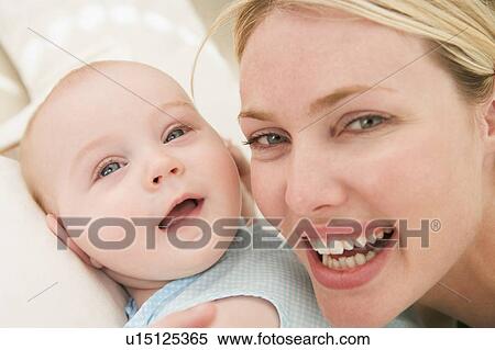 Stock Photography - Mother and baby indoors smiling. Fotosearch