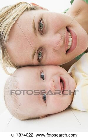 Mother and baby lying on floor smiling View Large Photo Image Stock Image - Mother and baby lying on floor smiling. Fotosearch
