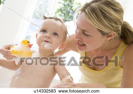Mother giving baby bubble bath smiling View Large Photo Image Stock Image - Mother giving baby bubble bath smiling. Fotosearch