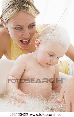 Mother giving baby bubble bath smiling View Large Photo Image Stock Image - Mother giving baby bubble bath smiling. Fotosearch