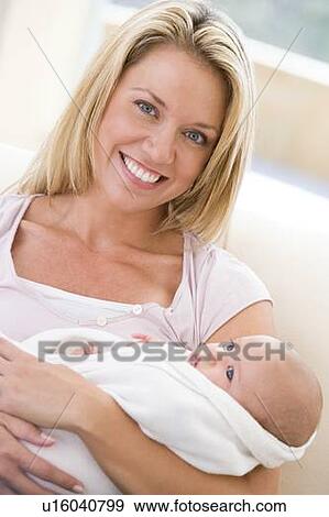 Stock Photo - Mother in living room with baby smiling. Fotosearch