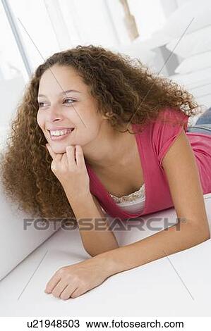 Woman lying in living room View Large Photo Image Stock Image - Woman lying in living room. Fotosearch