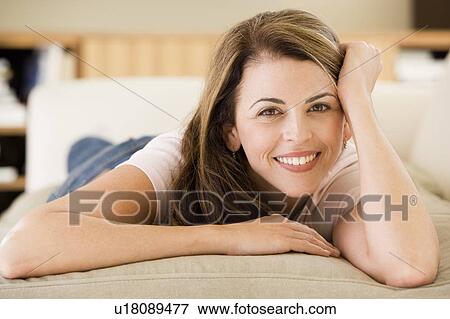 Stock Photo - Woman lying in living room. Fotosearch