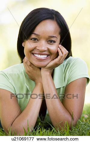 Stock Photo - Woman lying outdoors smiling. Fotosearch