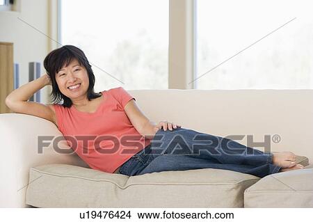 Woman relaxing in living room smiling View Large Photo Image Picture - Woman relaxing in living room smiling. Fotosearch