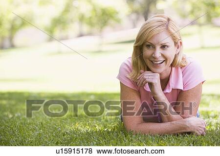 Woman relaxing outdoors smiling View Large Photo Image Stock Photo - Woman relaxing outdoors smiling. Fotosearch