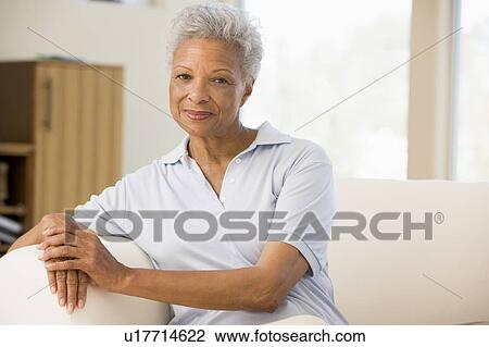 Woman sitting in living room View Large Photo Image Stock Image - Woman sitting in living room. Fotosearch