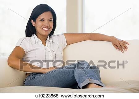 Woman sitting in living room View Large Photo Image Stock Photo - Woman sitting in living room. Fotosearch