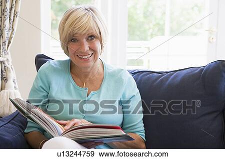 Woman with a book smiling View Large Photo Image Stock Photo - Woman with a book smiling. Fotosearch