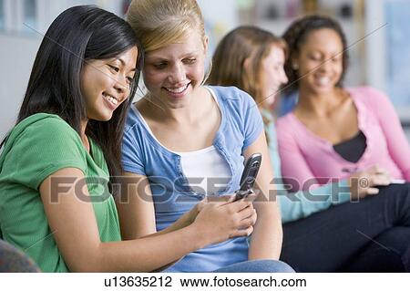 Female students looking at a mobile phone View Large Photo Image Stock Image - Female students looking at a mobile phone. Fotosearch