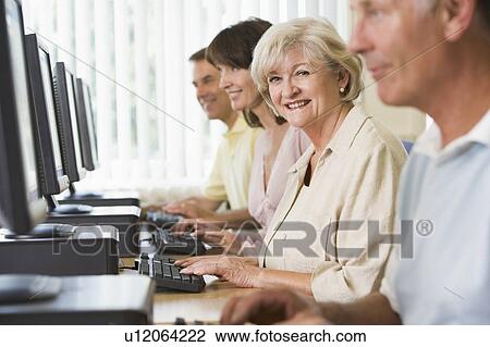 Four people sitting at computer terminals (selective focus/high key) View Large Photo Image Stock Image - Four people sitting at computer terminals (selective focus/high key). Fotosearch