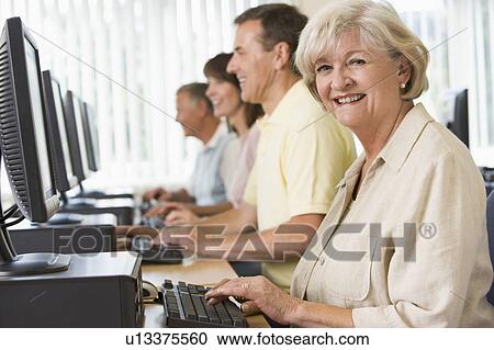 Four people sitting at computer terminals (depth of field/high key) View Large Photo Image Stock Image - Four people sitting at computer terminals (depth of field/high key). Fotosearch