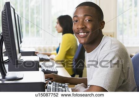 Man sitting at a computer terminal with woman in background (selective focus/high key) View Large Photo Image Stock Image - Man sitting at a computer terminal with woman in background (selective focus/high key). Fotosearch