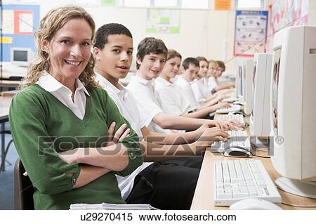 Students working on computer workstations with teacher View Large Photo Image Stock Photography - Students working on computer workstations with teacher. Fotosearch