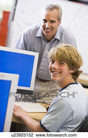 Teacher with male student in computer class View Large Photo Image Stock Image - Teacher with male student in computer class. Fotosearch