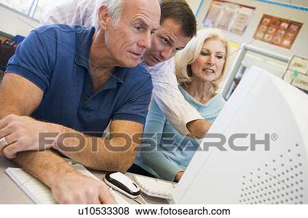 Three people at computer terminal View Large Photo Image Stock Photo - Three people at computer terminal. Fotosearch