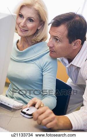 Two people at computer looking at monitor (high key) View Large Photo Image Picture - Two people at computer looking at monitor (high key). Fotosearch