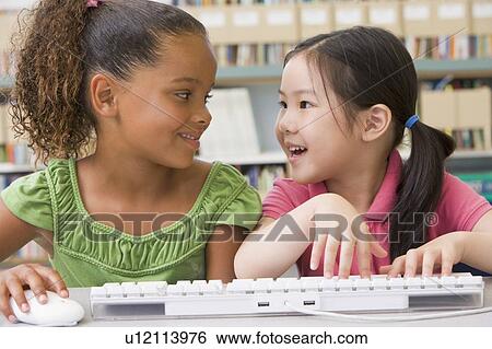 Two students in class at computer keyboard View Large Photo Image Stock Photograph - Two students in class at computer keyboard. Fotosearch