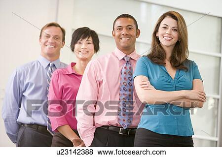 Stock Photo - Business team standing indoors smiling. Fotosearch