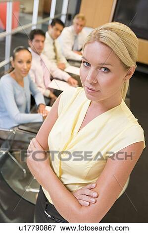 Businesswoman with four businesspeople at boardroom table in background View Large Photo Image Stock Photo - Businesswoman with four businesspeople at boardroom table in background. Fotosearch