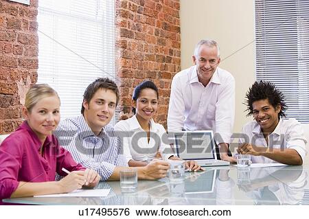 Five businesspeople in boardroom with laptop View Large Photo Image Stock Photograph - Five businesspeople in boardroom with laptop. Fotosearch