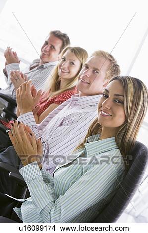 Picture - Four businesspeople applauding indoors smiling. Fotosearch
