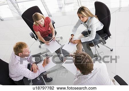 Four businesspeople in a boardroom with paperwork View Large Photo Image Stock Image - Four businesspeople in a boardroom with paperwork. Fotosearch