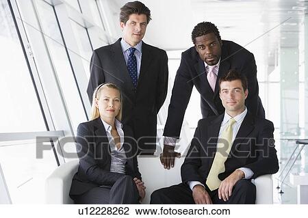 Four businesspeople in office lobby View Large Photo Image Stock Image - Four businesspeople in office lobby. Fotosearch