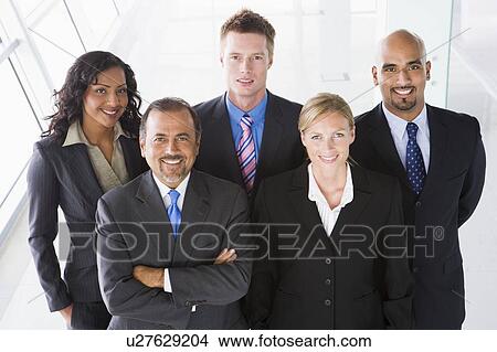 Group of co-workers standing in office space smiling (high key) View Large Photo Image Picture - Group of co-workers standing in office space smiling (high key). Fotosearch