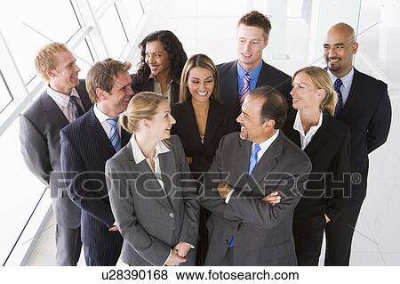 Stock Photo - Group of co-workers standing in office space smiling (high key). Fotosearch