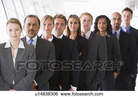 Stock Photograph - Group of co-workers standing in office space smiling (high key/depth of field). Fotosearch