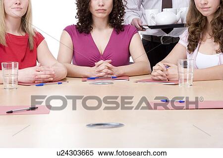 Three businesswomen sitting in boardroom being served coffee and tea View Large Photo Image Stock Photography - Three businesswomen sitting in boardroom being served coffee and tea. Fotosearch
