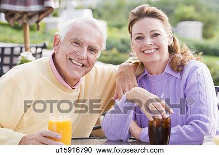 Stock Image - Couple Enjoying A Beverage By A Golf Course. Fotosearch