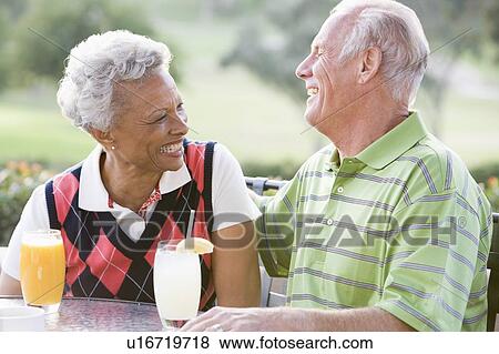 Stock Photo - Couple Enjoying A Beverage By A Golf Course. Fotosearch